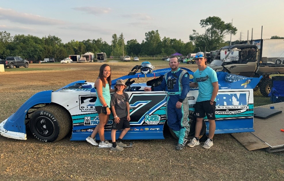 Family stands in front of their race car