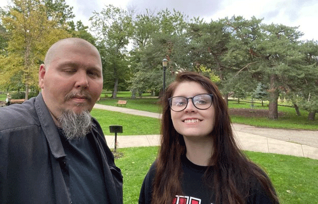 Scott stands next to his teenaged daughter. He eye droops, showing his MG symptoms